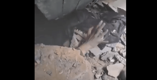 بالفيديو: امرأة غزية تمدّ يدها تحت الأنقاض لطلب النجدة