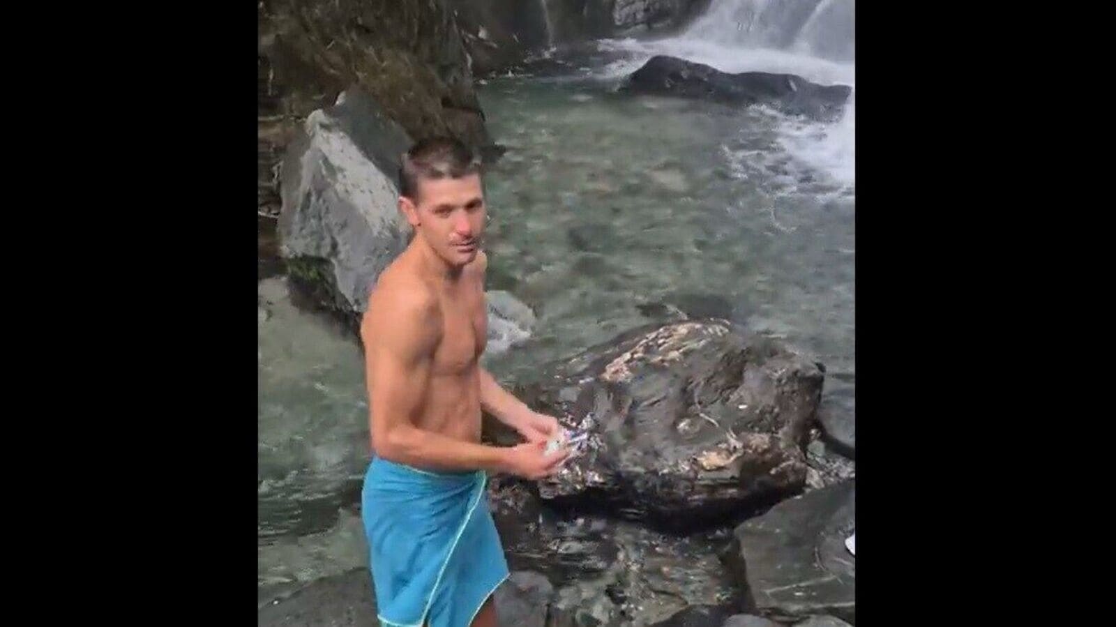 Foreign tourist cleans up garbage near Kangra waterfall as Indian visitors look on