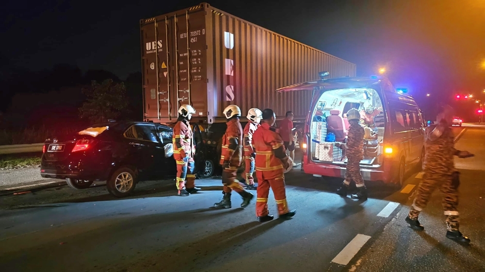 Firemen rescue driver after car slams into back of container lorry at Bintulu traffic light