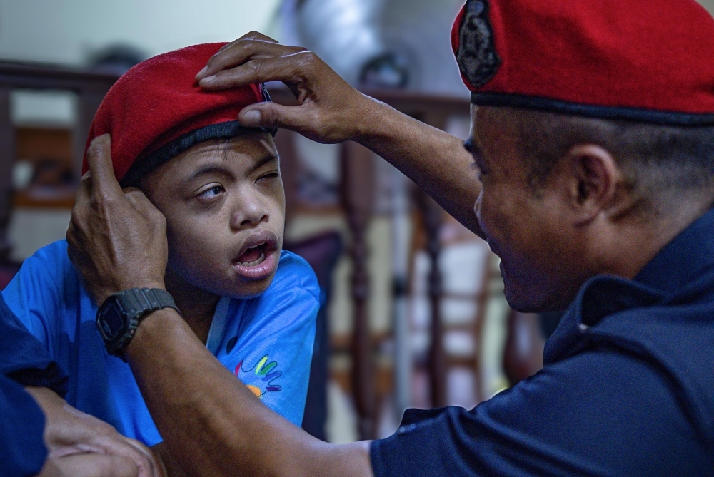 Heartbreaking moment as friend comforts late FRU officer's disabled son