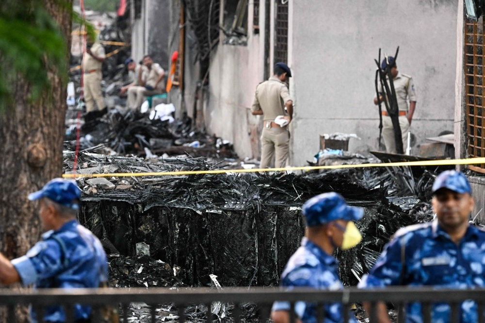 Sniffer dogs, rescuers comb crash site of Air India Dreamliner that killed at least 265 in India