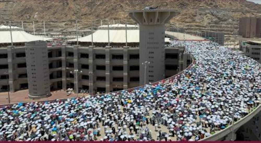 Pilgrims throw stones at Jamarat on the second day of Tashreeq